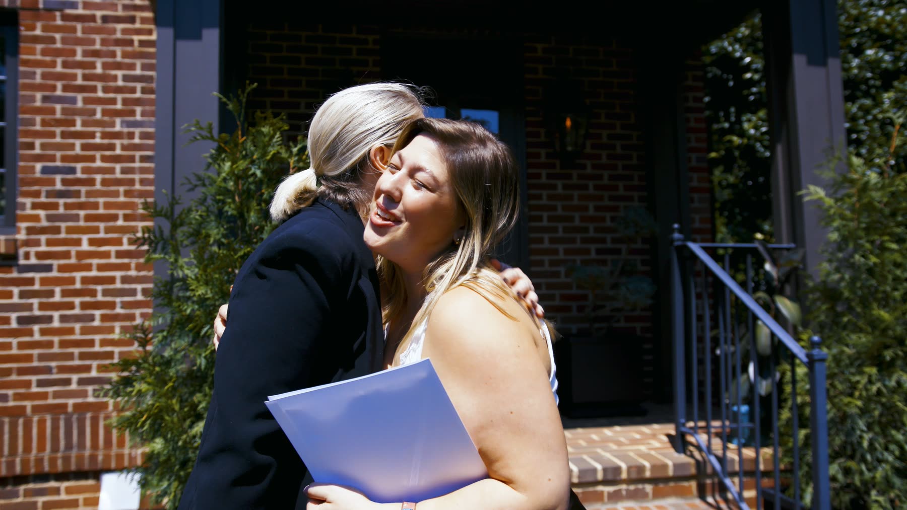 A Village Realty agent and her client on the front steps after closing