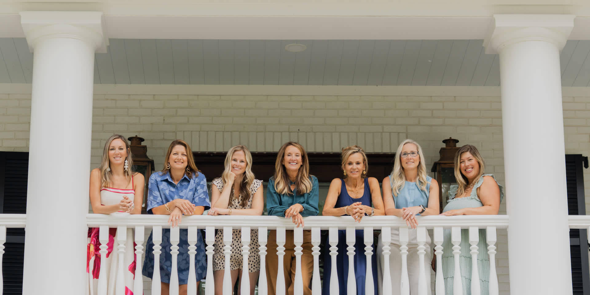 The Village Realty team together on the porch of a Winston-Salem home